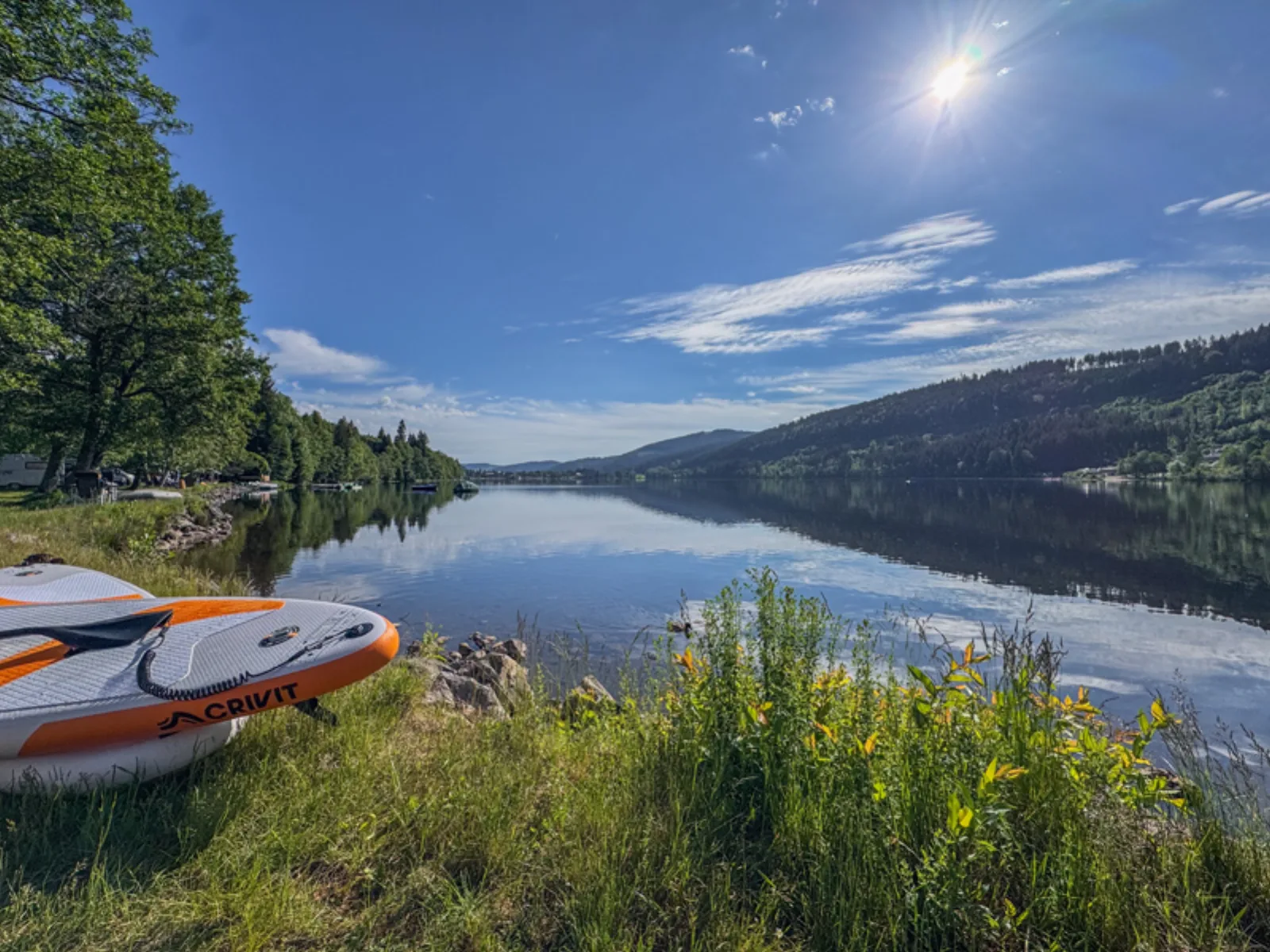 Calm morning view across Lake Titisee with paddleboards at the water's edge