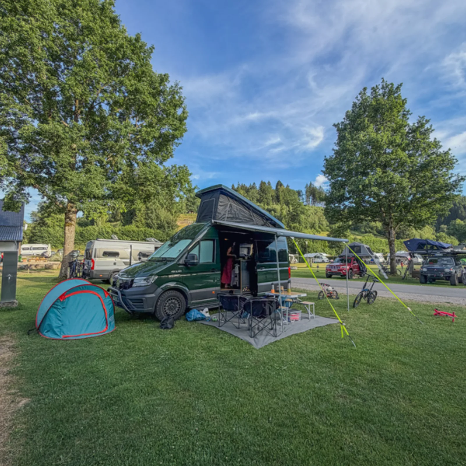 Campervan with awning out and a tent pitched alongside at Camping Wildbach