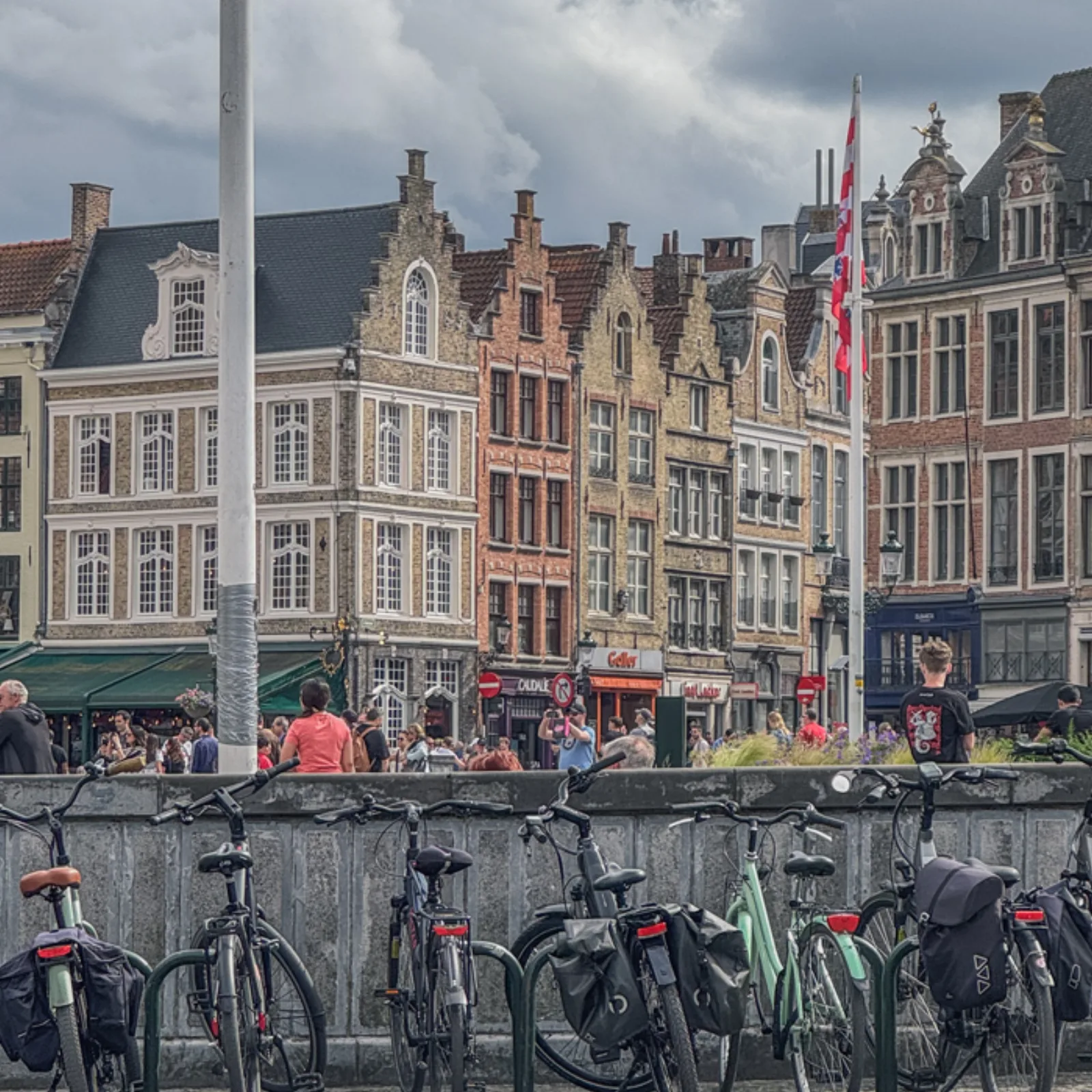 Bikes parked along a canal in front of the historic buildings of Bruges