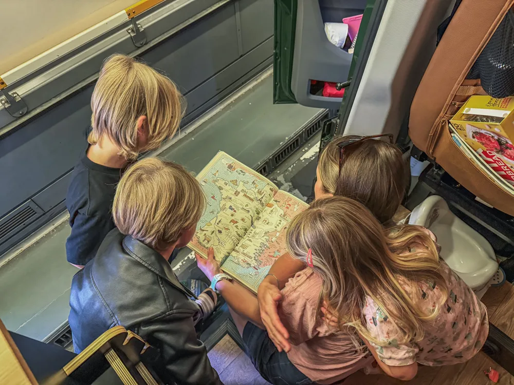 The children poring over a map in the back of the campervan