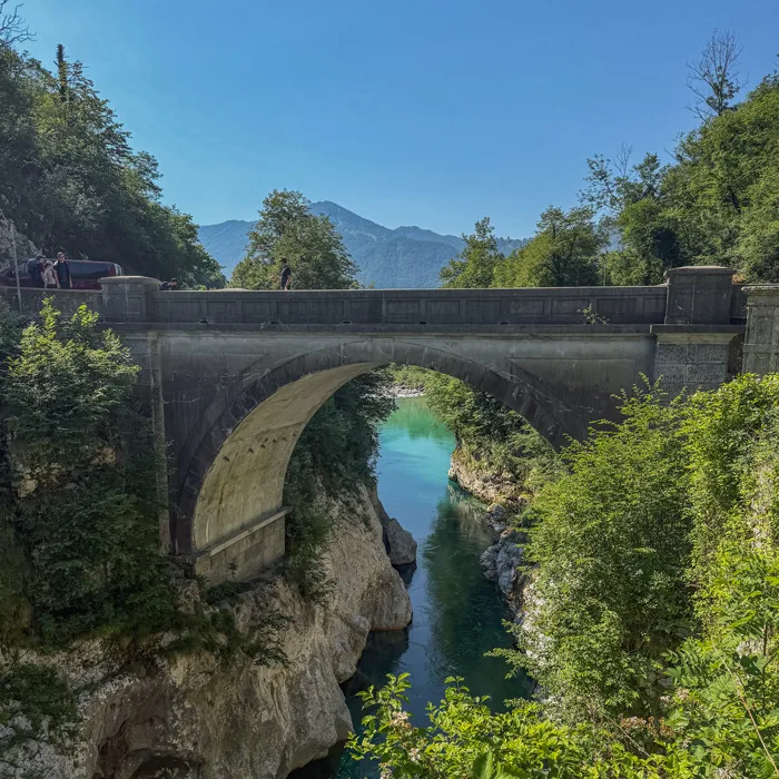 Stone bridge over the turquoise water of the Soča river