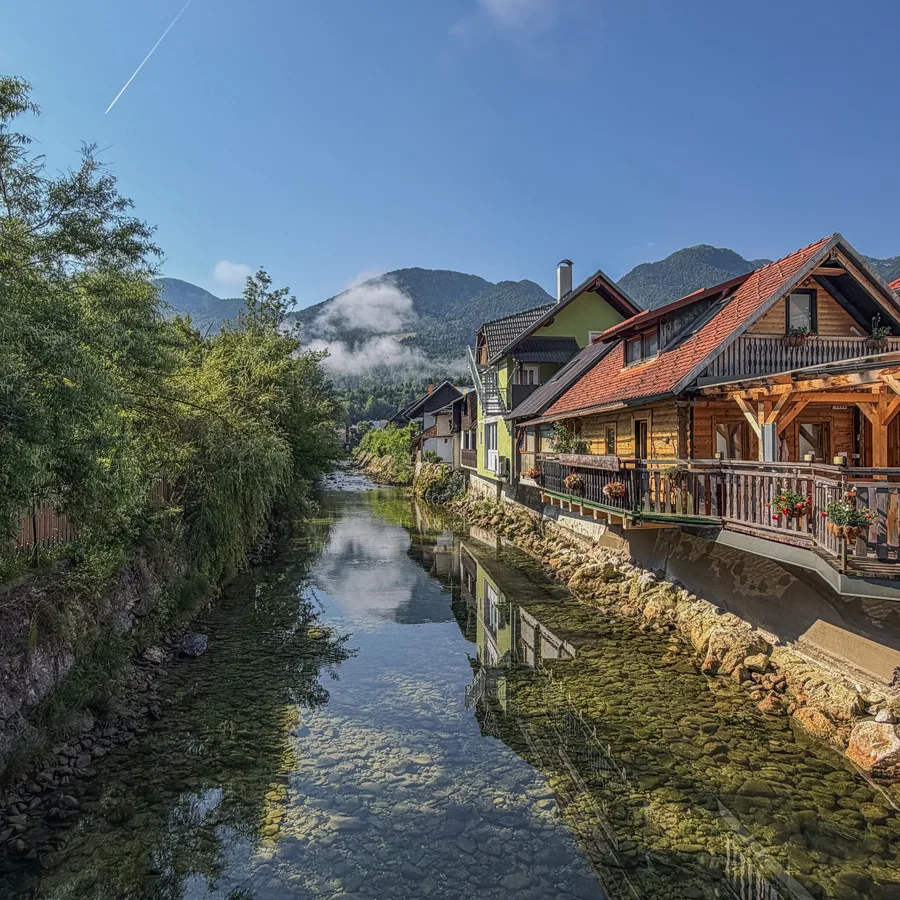 Traditional Slovenian houses lining the river on the cycle to Lake Bohinj