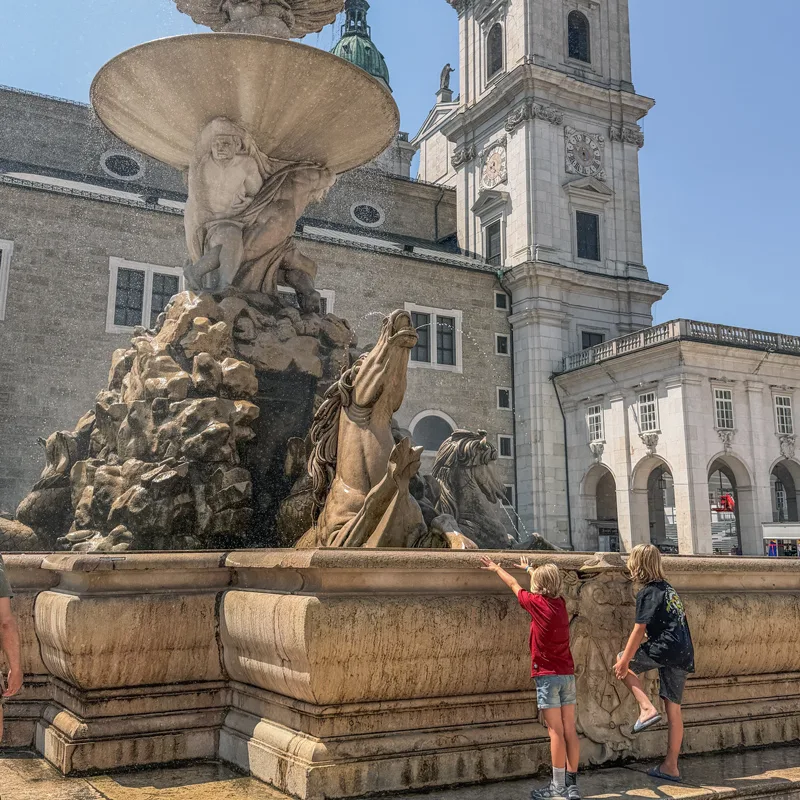The children exploring the fountain in Salzburg's Residenzplatz
